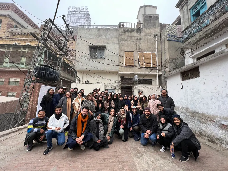 A group of students with a Lahore ka Ravi Storyteller in the old city
